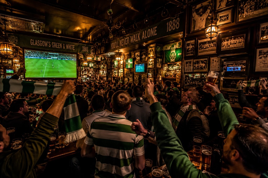 Celtic supporters watching a live match in a pub